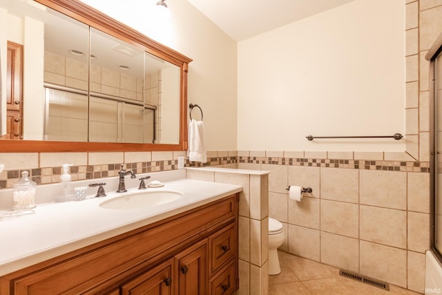 4000 E Stonegate Dr, Bloomington, IN 47401 - bathroom with vanity, tile walls, a shower with door, toilet, and tile patterned flooring