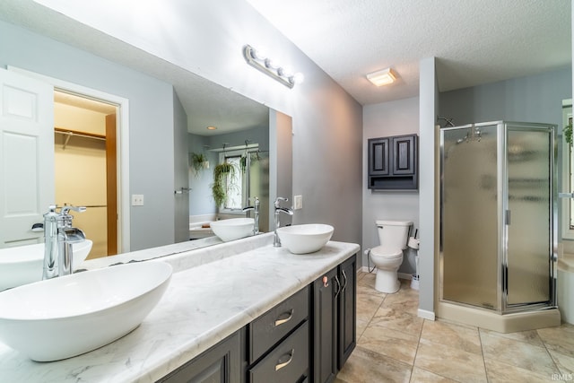 15304 Wild Meadows Pl, Leo, IN 46765 - full bath featuring a stall shower, double vanity, toilet, a textured ceiling, and a spacious closet