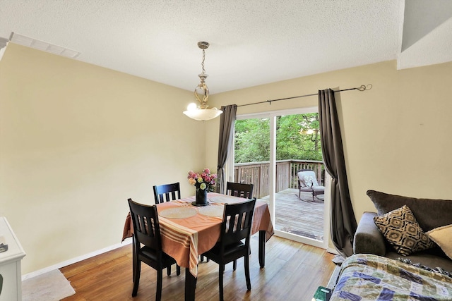 2210 S Laurelwood Cir, Bloomington, IN 47401 - dining room with wood finished floors, a textured ceiling, and baseboards
