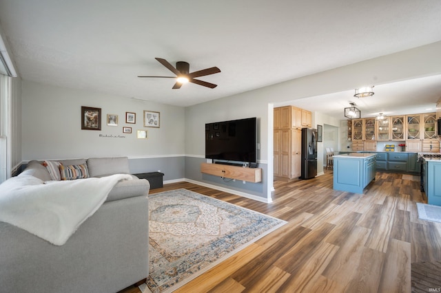 7805 W Kennedy Pkwy, Yorktown, IN 47396 - living room featuring light wood-style flooring, a ceiling fan, and baseboards