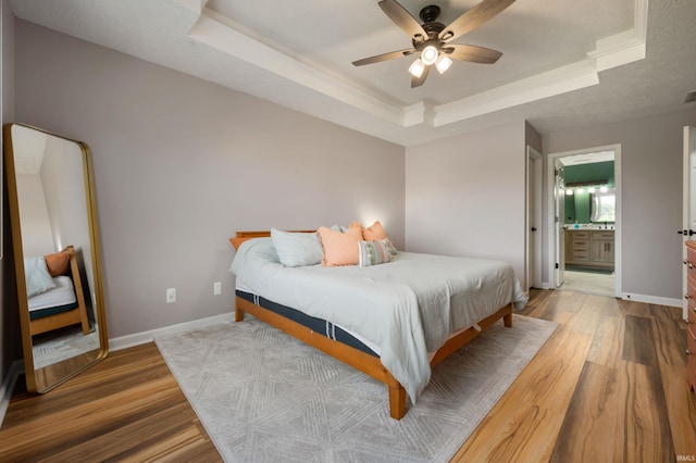 7805 W Kennedy Pkwy, Yorktown, IN 47396 - bedroom featuring a raised ceiling, wood finished floors, baseboards, crown molding, and connected bathroom