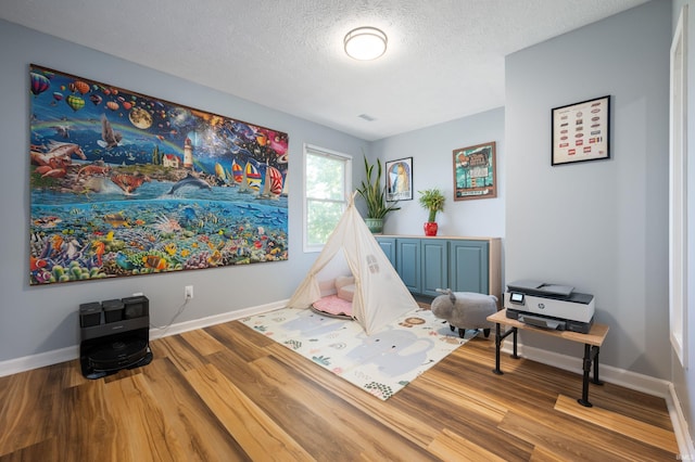 7805 W Kennedy Pkwy, Yorktown, IN 47396 - game room with wood finished floors, a textured ceiling, and baseboards