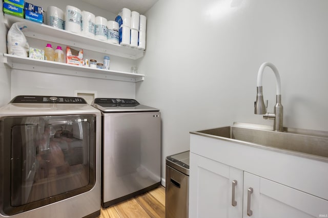 7805 W Kennedy Pkwy, Yorktown, IN 47396 - washroom featuring separate washer and dryer, cabinet space, and light wood-style floors