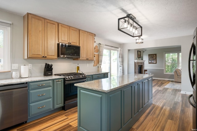 7805 W Kennedy Pkwy, Yorktown, IN 47396 - kitchen featuring appliances with stainless steel finishes, wood finished floors, open floor plan, healthy amount of natural light, and a textured ceiling