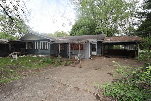 56825 Elmer Ave, South Bend, IN 46619 - back of house featuring a sunroom, a carport, and a patio