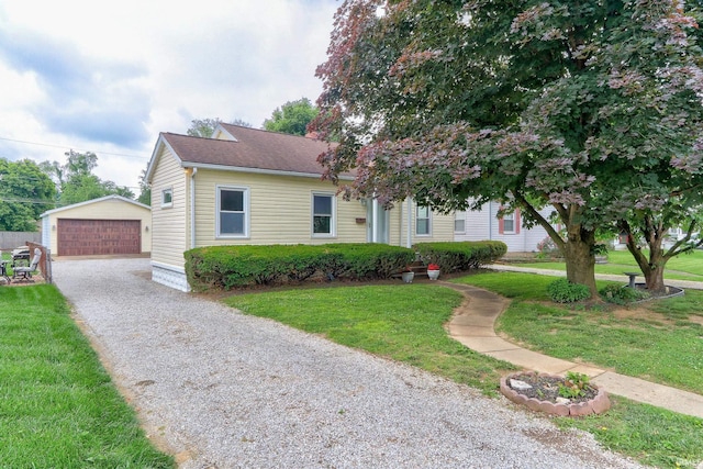2305 E Virginia St, Evansville, IN 47711 - view of front of house with an outbuilding, a front yard, a garage, and a shingled roof