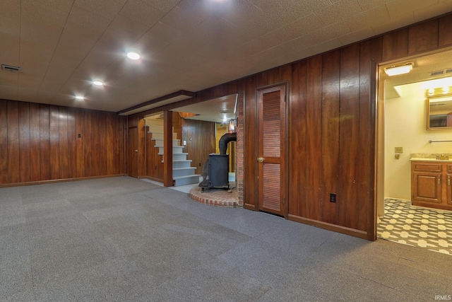 2305 E Virginia St, Evansville, IN 47711 - finished basement with wooden walls, stairway, a wood stove, carpet flooring, and baseboards