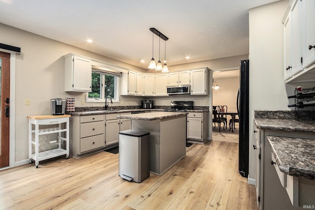 50576 W Park Ln, Granger, IN 46530 - kitchen with black appliances, a sink, light wood-style floors, recessed lighting, and a kitchen island