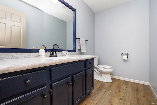 50576 W Park Ln, Granger, IN 46530 - bathroom featuring vanity, wood finished floors, baseboards, and toilet