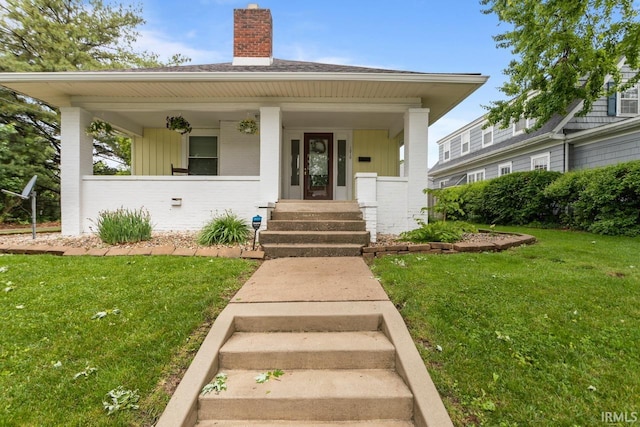 1010 W Sycamore St, Kokomo, IN 46901 - bungalow featuring a chimney, a front lawn, a porch, and brick siding
