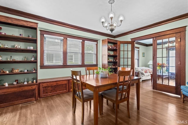 1010 W Sycamore St, Kokomo, IN 46901 - dining room with a chandelier, wood finished floors, crown molding, and healthy amount of natural light