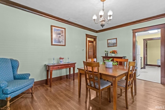 1010 W Sycamore St, Kokomo, IN 46901 - dining space with a chandelier, ornamental molding, wood finished floors, and baseboards