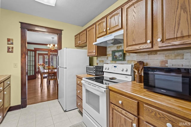 1010 W Sycamore St, Kokomo, IN 46901 - kitchen with white appliances, under cabinet range hood, butcher block countertops, backsplash, and a chandelier