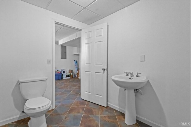 1010 W Sycamore St, Kokomo, IN 46901 - half bathroom featuring toilet, electric panel, baseboards, tile patterned floors, and a drop ceiling