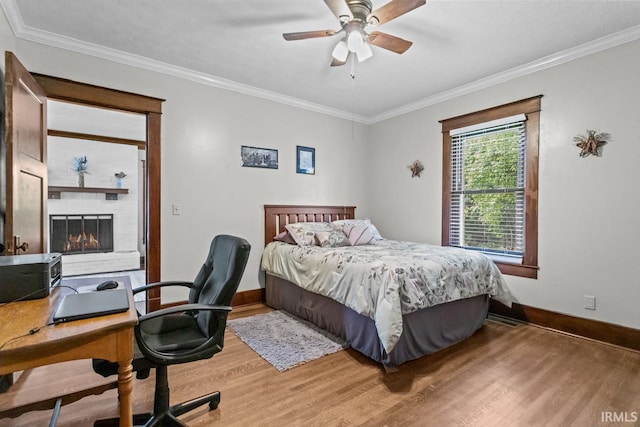 1010 W Sycamore St, Kokomo, IN 46901 - bedroom with wood finished floors, baseboards, ornamental molding, a brick fireplace, and an office area