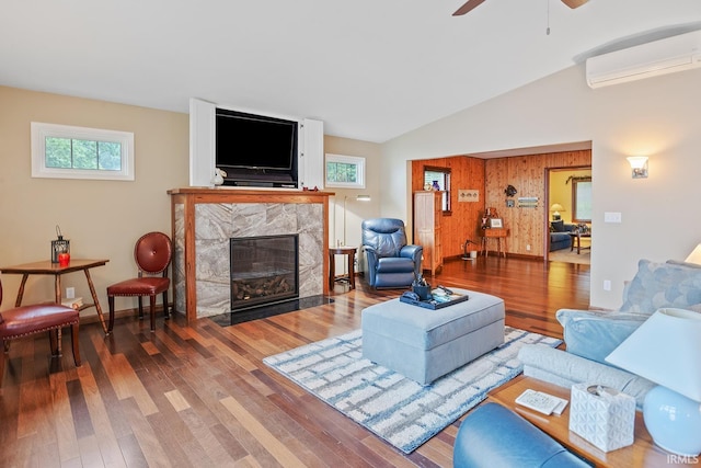 8818 N 1132 W, Monticello, IN 47960 - living room featuring an AC wall unit, a fireplace, wood finished floors, a ceiling fan, and vaulted ceiling
