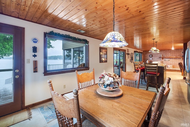 8818 N 1132 W, Monticello, IN 47960 - dining space featuring light tile patterned floors, baseboards, brick wall, and wooden ceiling