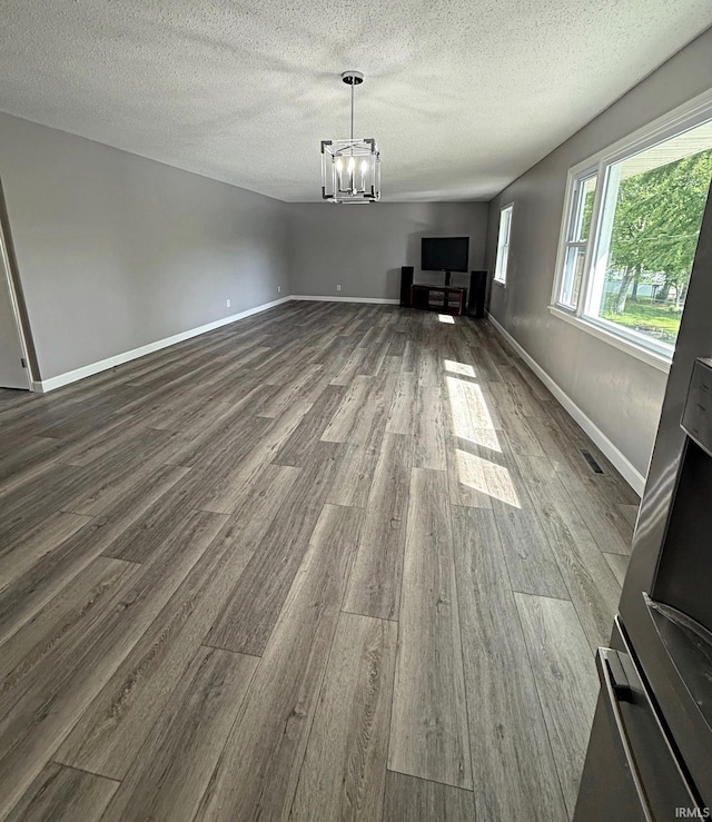 2124 Lakeview Dr, Washington, IN 47501 - unfurnished living room featuring dark wood-style floors, a chandelier, a textured ceiling, and baseboards