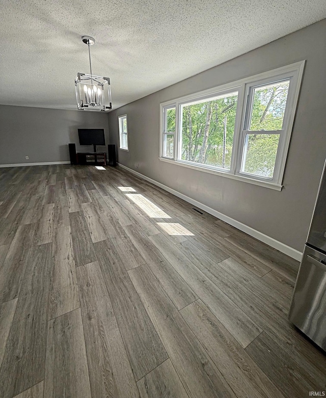 2124 Lakeview Dr, Washington, IN 47501 - unfurnished living room featuring dark wood-style floors, a chandelier, baseboards, and a textured ceiling