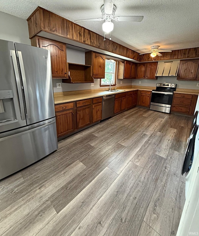 2124 Lakeview Dr, Washington, IN 47501 - kitchen featuring appliances with stainless steel finishes, a textured ceiling, light countertops, wood finished floors, and a sink