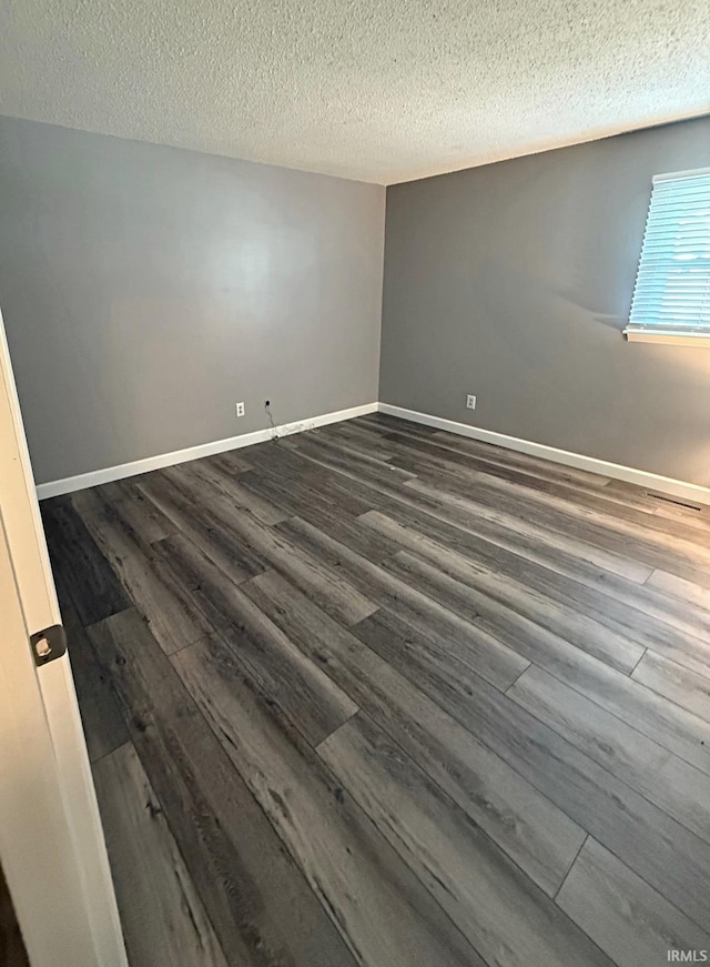 2124 Lakeview Dr, Washington, IN 47501 - spare room featuring dark wood finished floors, a textured ceiling, and baseboards