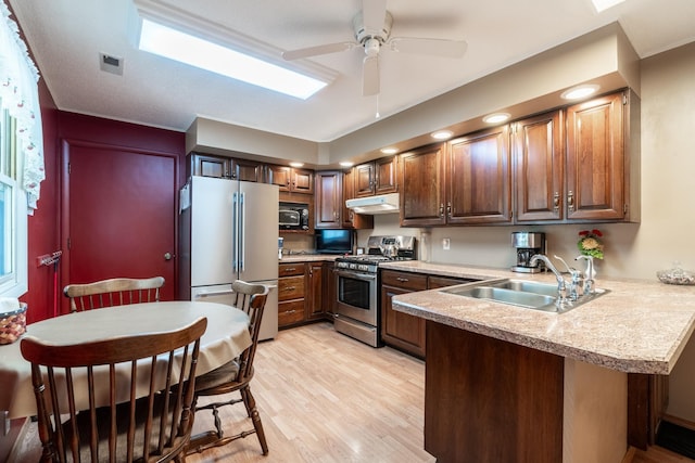 705 W W Spg, Fremont, IN 46737 - kitchen featuring freestanding refrigerator, stainless steel gas range, a sink, under cabinet range hood, and a peninsula