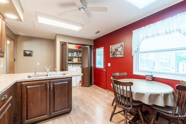 705 W W Spg, Fremont, IN 46737 - kitchen with a sink, washer and clothes dryer, light wood finished floors, and healthy amount of natural light
