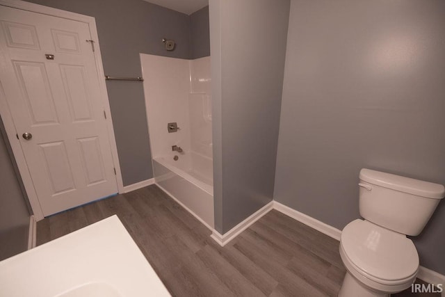 1034 Harter Blvd, Anderson, IN 46011 - bathroom featuring wood finished floors, toilet, baseboards, and bathtub / shower combination