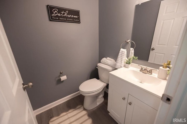 1034 Harter Blvd, Anderson, IN 46011 - half bath featuring toilet, vanity, wood finished floors, and baseboards
