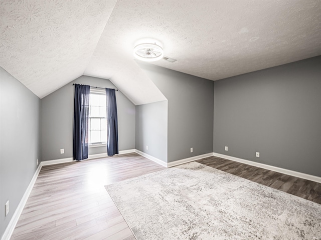 2747 Thornhill Dr, Evansville, IN 47725 - bonus room with wood finished floors, a textured ceiling, vaulted ceiling, and baseboards