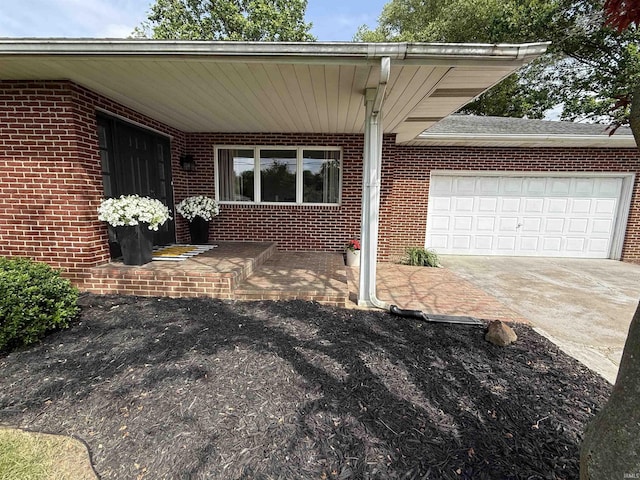 5522 N State Rd 57, Petersburg, IN 47567 - doorway to property featuring concrete driveway, an attached garage, and brick siding