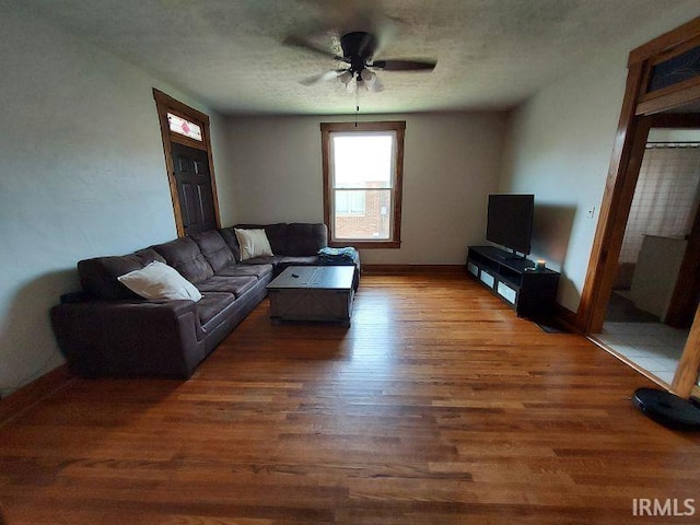 306 E 8th St, Jasper, IN 47546 - living area with wood finished floors, a ceiling fan, baseboards, and a textured ceiling