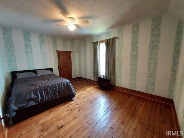 306 E 8th St, Jasper, IN 47546 - bedroom with wallpapered walls, hardwood / wood-style flooring, baseboards, and a ceiling fan