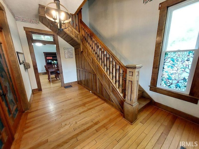 306 E 8th St, Jasper, IN 47546 - stairway featuring a chandelier, hardwood / wood-style flooring, and baseboards