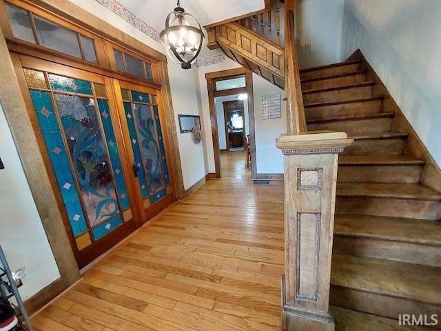 306 E 8th St, Jasper, IN 47546 - entrance foyer with stairs, light wood-style flooring, a chandelier, and baseboards