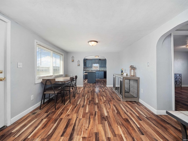 3780 S 550 E, Hamilton, IN 46742 - dining space featuring arched walkways, dark wood-style floors, baseboards, and a textured ceiling