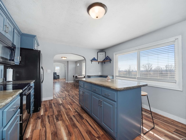 3780 S 550 E, Hamilton, IN 46742 - kitchen featuring blue cabinets, black appliances, arched walkways, a kitchen island, and dark wood finished floors