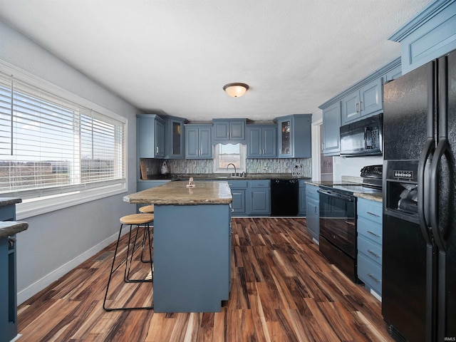 3780 S 550 E, Hamilton, IN 46742 - kitchen featuring black appliances, blue cabinets, glass insert cabinets, and plenty of natural light