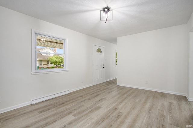 718 W 8th St, Mishawaka, IN 46544 - empty room featuring a baseboard heating unit, light wood finished floors, and baseboards