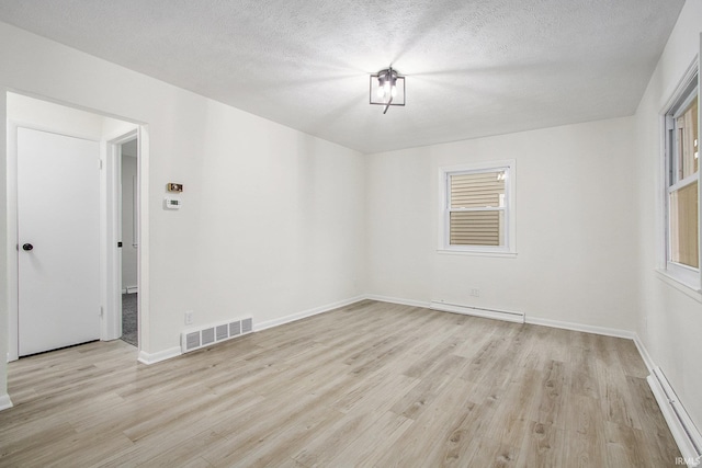 718 W 8th St, Mishawaka, IN 46544 - unfurnished room with baseboard heating, light wood finished floors, plenty of natural light, and a textured ceiling