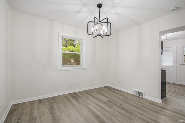 718 W 8th St, Mishawaka, IN 46544 - unfurnished room with wood finished floors, a chandelier, a smoke detector, and baseboards