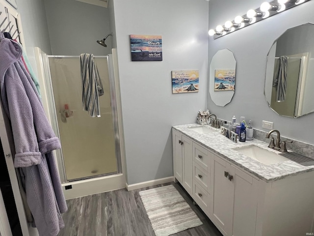 2940 N Stanford Woods Dr, Solsberry, IN 47459 - full bathroom with a shower stall, double vanity, wood finished floors, and baseboards
