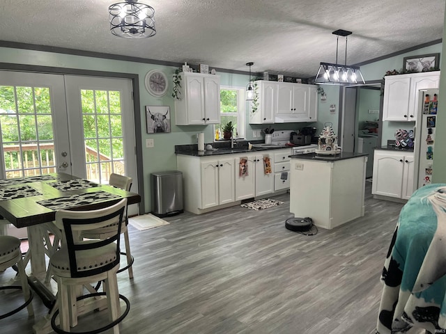 2940 N Stanford Woods Dr, Solsberry, IN 47459 - kitchen with a textured ceiling, white cabinets, dark countertops, a center island, and wood finished floors