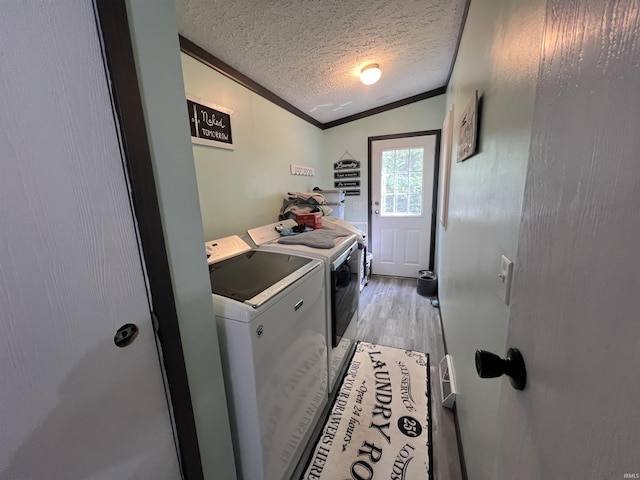 2940 N Stanford Woods Dr, Solsberry, IN 47459 - laundry room featuring independent washer and dryer, ornamental molding, light wood finished floors, and a textured ceiling