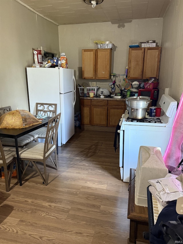 1214 Spear St, Logansport, IN 46947 - kitchen featuring white appliances, brown cabinetry, and light wood-style floors