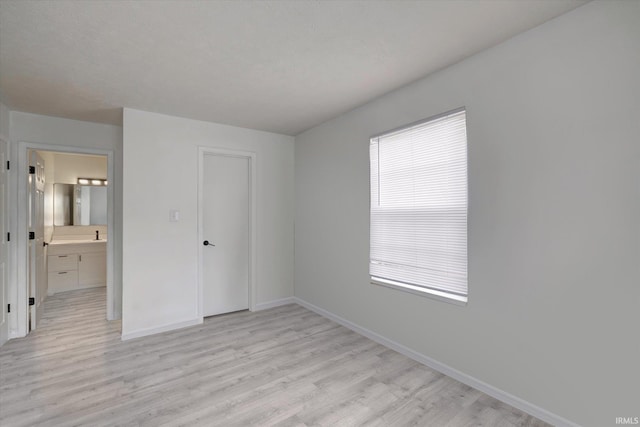 3220 E John Hinkle Pl Unit F, Bloomington, IN 47408 - unfurnished bedroom with baseboards and light wood finished floors
