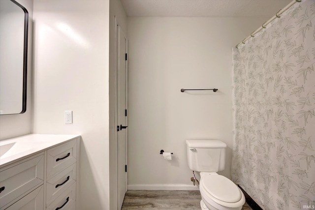 3220 E John Hinkle Pl Unit F, Bloomington, IN 47408 - bathroom featuring vanity, wood finished floors, toilet, and baseboards