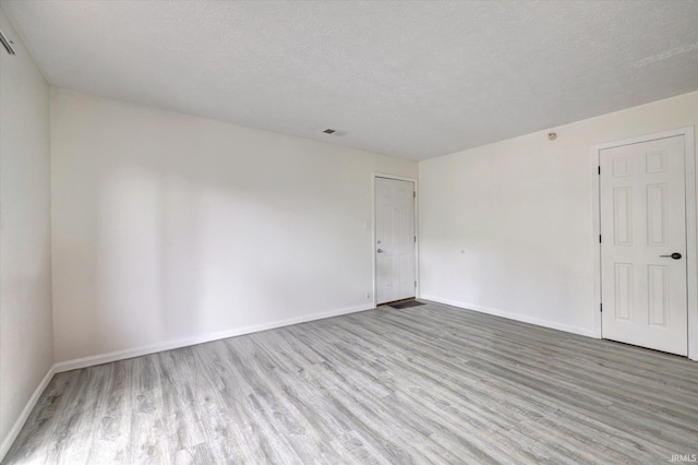 3220 E John Hinkle Pl Unit F, Bloomington, IN 47408 - empty room with wood finished floors, baseboards, and a textured ceiling