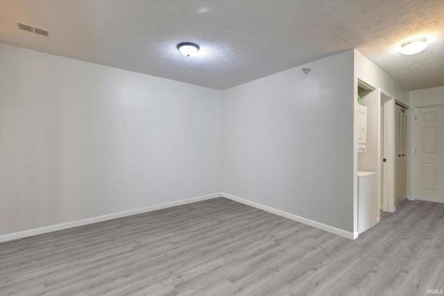3220 E John Hinkle Pl Unit F, Bloomington, IN 47408 - spare room featuring a textured ceiling, light wood-style flooring, and baseboards