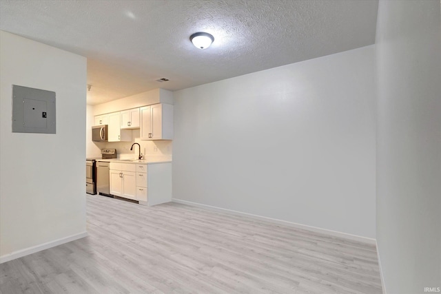 3220 E John Hinkle Pl Unit F, Bloomington, IN 47408 - kitchen featuring electric panel, a sink, appliances with stainless steel finishes, light wood finished floors, and a textured ceiling